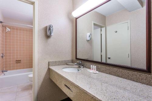 a bathroom with a sink and a mirror at Ramada by Wyndham Triangle/Quantico in Triangle