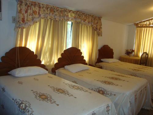 a hotel room with two beds and a window at Hotel Sol del Oriente Iquitos in Iquitos