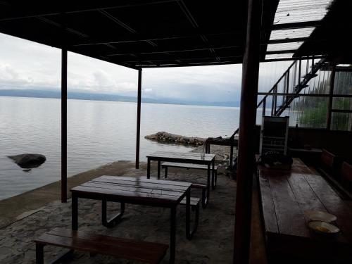 a room with benches and a view of the water at Pondok Berata Dapdap in Balige