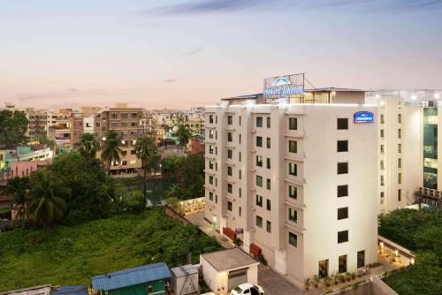 a white building with a sign on top of it at Howard Johnson by Wyndham, Kolkata Airport in Kolkata