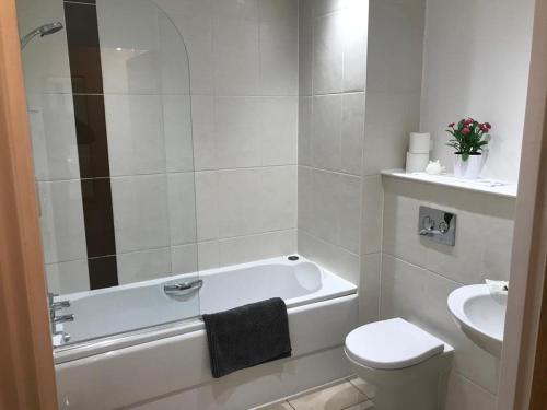 a bathroom with a tub and a toilet and a sink at Hansen House Cardiff Apartment with Parking in Cardiff