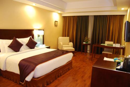 a hotel room with a large bed and a desk at Gokulam Park Sabari-Siruseri SIPCOT in Chennai
