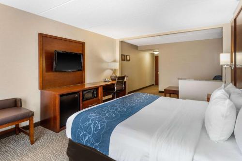 a hotel room with a bed and a flat screen tv at Comfort Suites Manassas Battlefield Park in Manassas