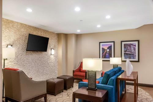 a living room with a couch and chairs and a tv at Comfort Inn & Suites At Copeland Tower in Metairie
