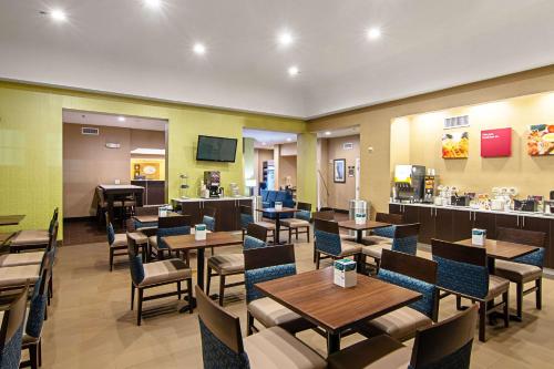 a restaurant with tables and chairs and a piano at Comfort Suites NW Dallas Near Love Field in Dallas