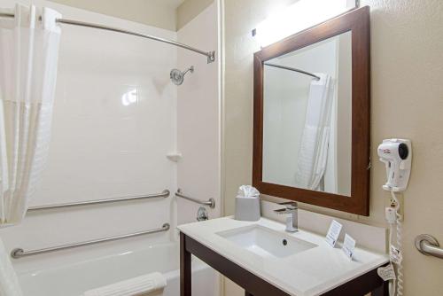 a bathroom with a sink, mirror and bath tub at Comfort Suites NW Dallas Near Love Field in Dallas