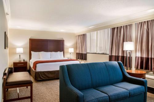 a hotel room with a bed and a blue couch at Comfort Inn & Suites At Copeland Tower in Metairie