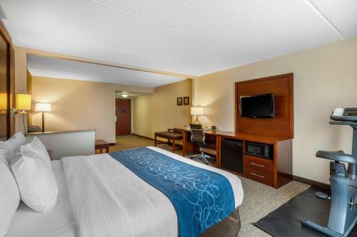 a hotel room with a bed and a desk with a television at Comfort Suites Manassas Battlefield Park in Manassas