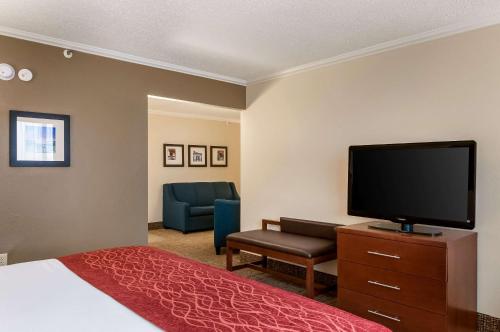 a hotel room with a bed and a flat screen tv at Comfort Inn & Suites At Copeland Tower in Metairie