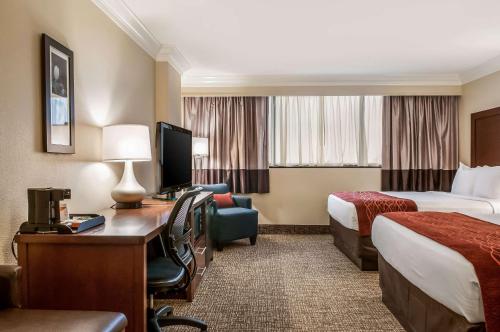a hotel room with two beds and a desk with a computer at Comfort Inn & Suites At Copeland Tower in Metairie