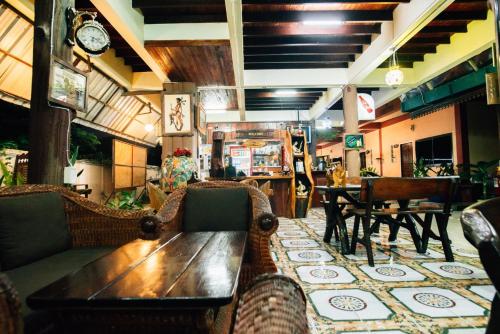 a restaurant with a wooden table and chairs at Noble Night Guesthouse in Kanchanaburi