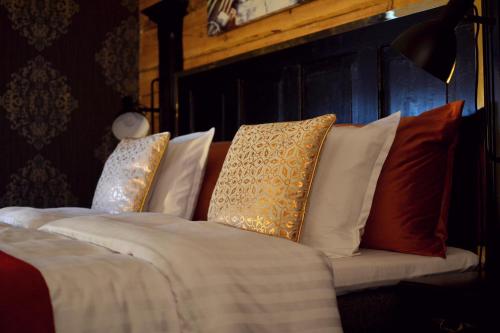 a bed with pillows on it in a room at Putiikkihotelli Kemi 1932 in Kemi