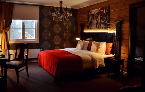 a bedroom with a bed and a chandelier at Putiikkihotelli Kemi 1932 in Kemi