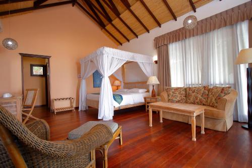 a living room with a bed and a couch at Sutera at Mantanani Island Resort & Spa in Mantanani Island 