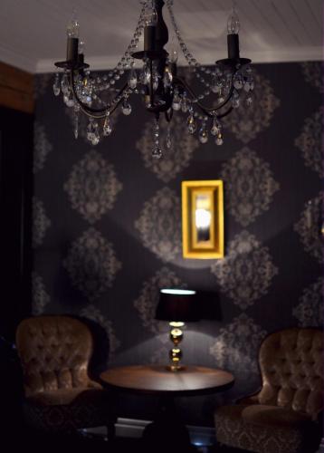 a room with a table and chairs and a chandelier at Putiikkihotelli Kemi 1932 in Kemi
