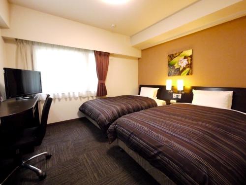Postel nebo postele na pokoji v ubytování Hotel Route-Inn Yokohama Bashamichi