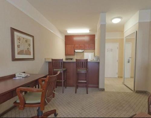 
a kitchen with a table, chairs and a refrigerator at Holiday Inn Express Hotel & Suites San Dimas, an IHG Hotel in San Dimas
