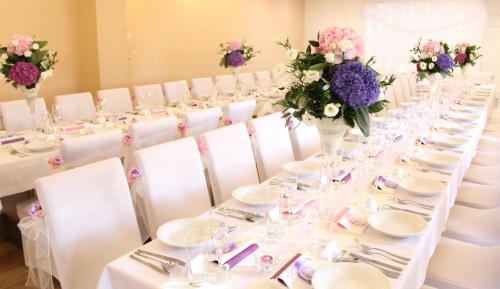 a table set up for a wedding with purple and purple flowers at Penzión u Vinára in Veľký Krtíš
