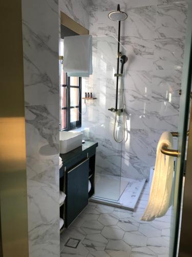 a bathroom with a sink and a shower at Moon and Chalice Boutique Hotel in Kunming