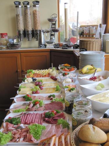 a table with many different types of food on it at Landhotel Dresden in Dresden