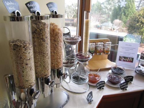 a counter with containers of food and glasses of wine at Landhotel Dresden in Dresden