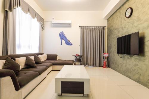 een woonkamer met een bank en een tv bij Miyue B&B in Magong