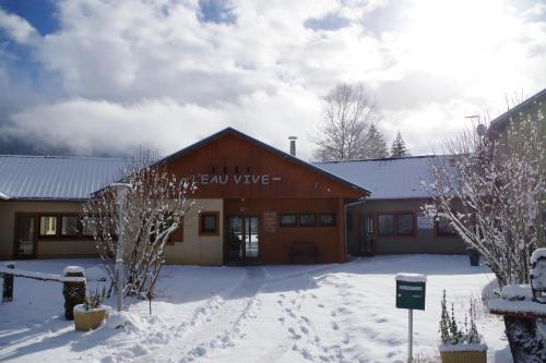 a building with snow on the ground in front of it at Eau Vive in Lescheraines