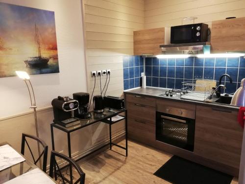 a kitchen with a sink and a stove top oven at Datcha Bourguignonne Beaune in Beaune