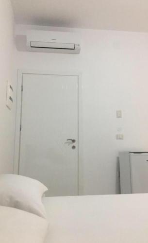 a white room with a bed and a door at Villa Orkidea in Sarandë