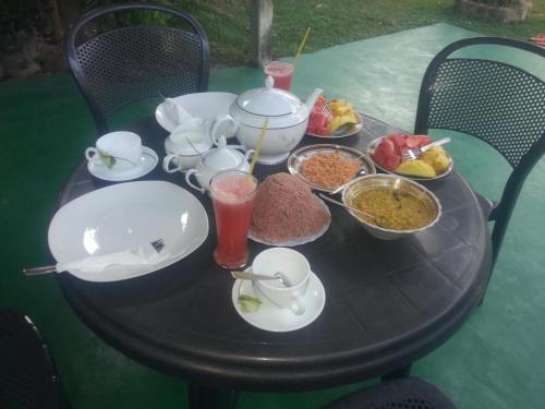 a table with plates and bowls of food on it at Thalalla BnB in Talalla