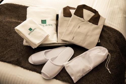 einen Haufen Handtücher und Schuhe auf einem Bett in der Unterkunft Kyoto Gion U-BELL Hotel in Kyoto