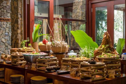 un buffet de denrées alimentaires et de plantes sur une table dans l'établissement Hoi An Eco Lodge & Spa, à Hội An