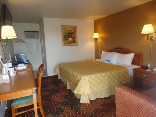 聖塔羅莎的住宿－Americas Best Value Inn Santa Rosa, New Mexico，配有一张床和一张书桌的酒店客房