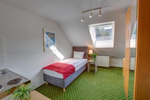 a small bedroom with a bed and a window at Hotel Leo Mühlhausen in Mühlhausen