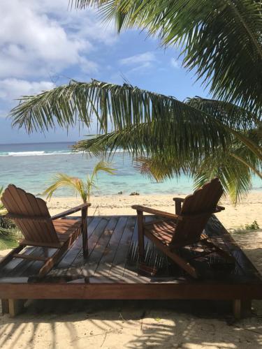 two chairs and a table on a beach at Serenity Villas Rarotonga in Rarotonga