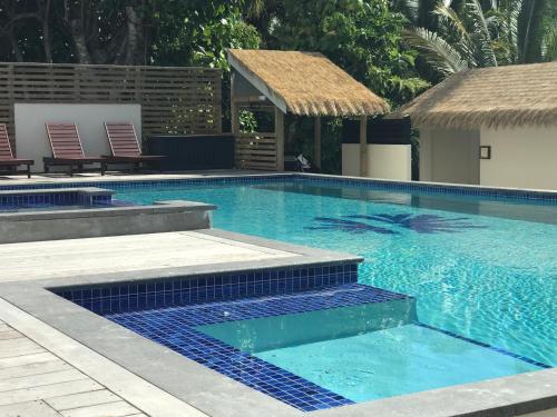 a swimming pool with blue tiles in a resort at Serenity Villas Rarotonga in Rarotonga