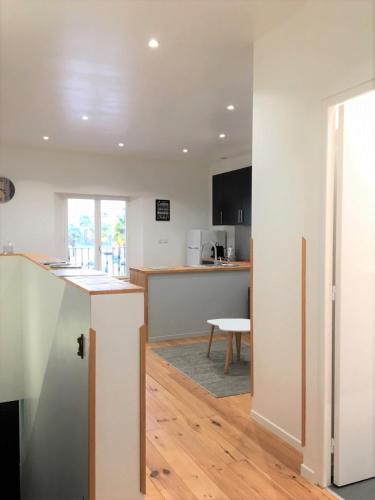 an open kitchen and living room with a table at Le T2 moderne des Palmiers au coeur de Moissac in Moissac