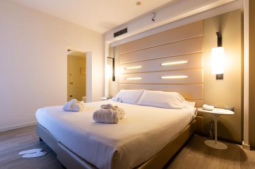 a bedroom with a large bed with towels on it at Best Western Plus Tower Hotel Bologna in Bologna