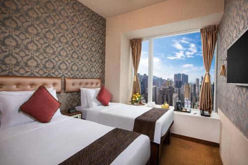 a hotel room with two beds and a large window at Ramada Hong Kong Harbour View in Hong Kong