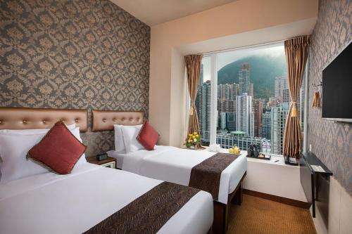Habitación de hotel con 2 camas y ventana en Ramada Hong Kong Harbour View en Hong Kong