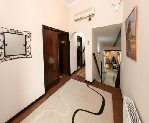 a hallway with a rug on the floor and a mirror at The Villa of the Winds in Néa Kíos