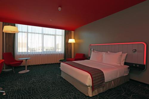 a hotel room with a large bed and a window at Park Inn by Radisson Najran in Najran