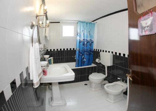 a bathroom with a sink and a toilet and a tub at The Villa of the Winds in Néa Kíos