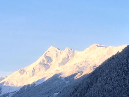 a snow covered mountain with a blue sky in the background at Haus Steinbock in Neustift im Stubaital