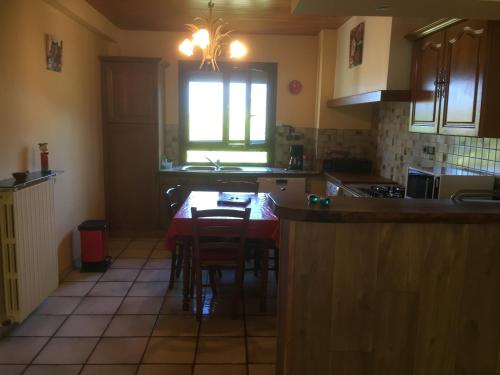 une cuisine avec une table et des chaises et une fenêtre dans l'établissement Lieu dit les Allemands, à Embrun