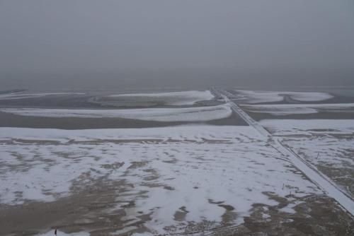a road in the middle of a field with snow at Studio On The Beach With Sea View in Middelkerke