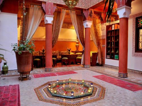 Riad Lila في مراكش: غرفة كبيرة مع طاولة وغرفة كبيرة مع مسبح في الوسط