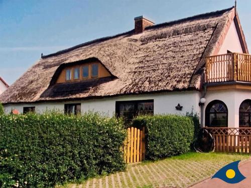 a large house with a thatched roof at Haus Ueckeritz Loggiawohnung in Ueckeritz