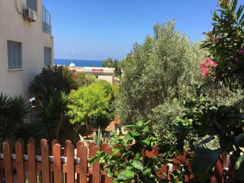 a fence in front of a house with trees at Diamond Complex in Paphos City