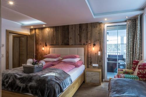a bedroom with a large bed with wooden walls at Villa Ambach in Oetz